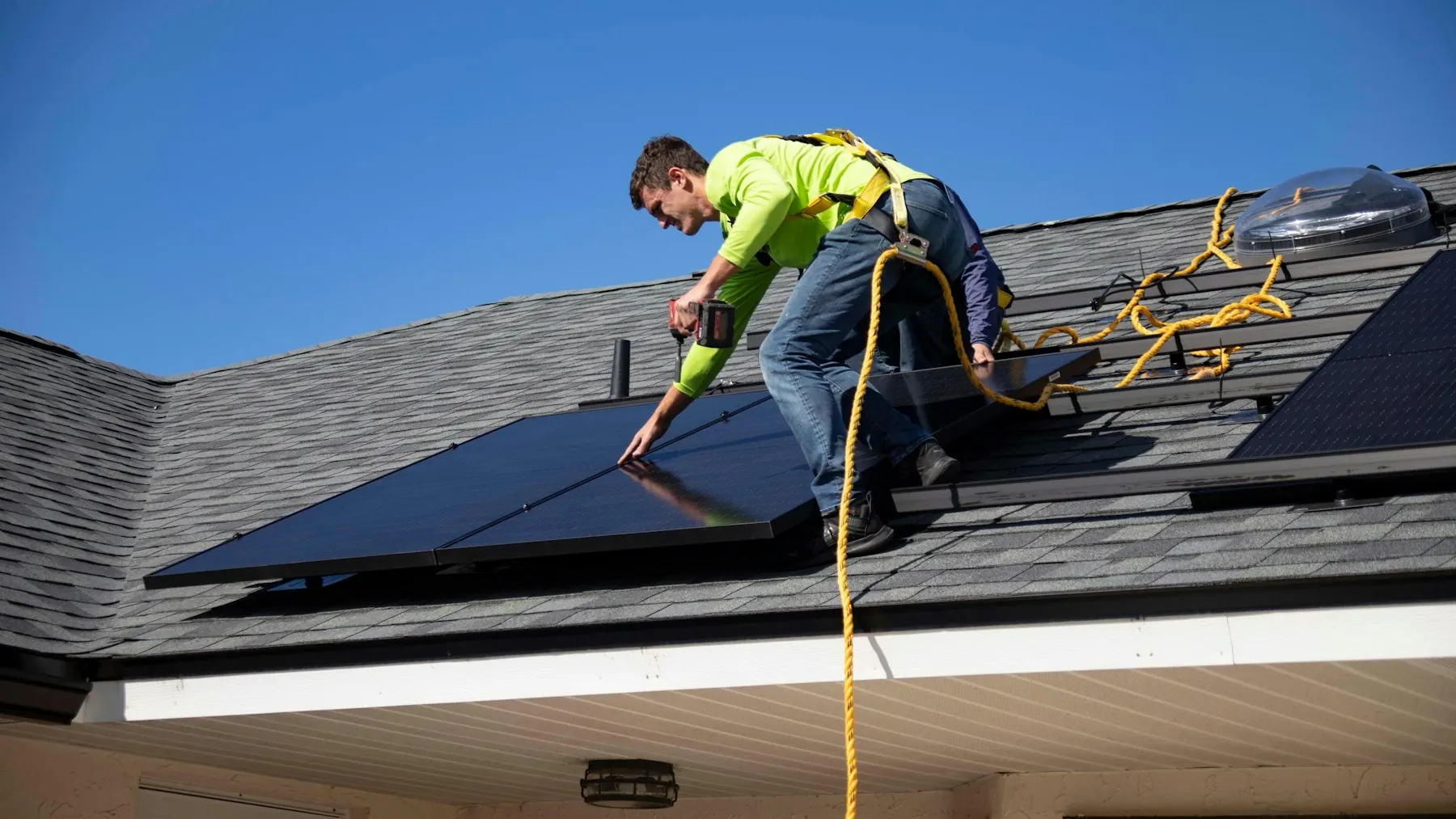 Monteur setzt ein Photovoltaikmodul auf ein Schrägdach