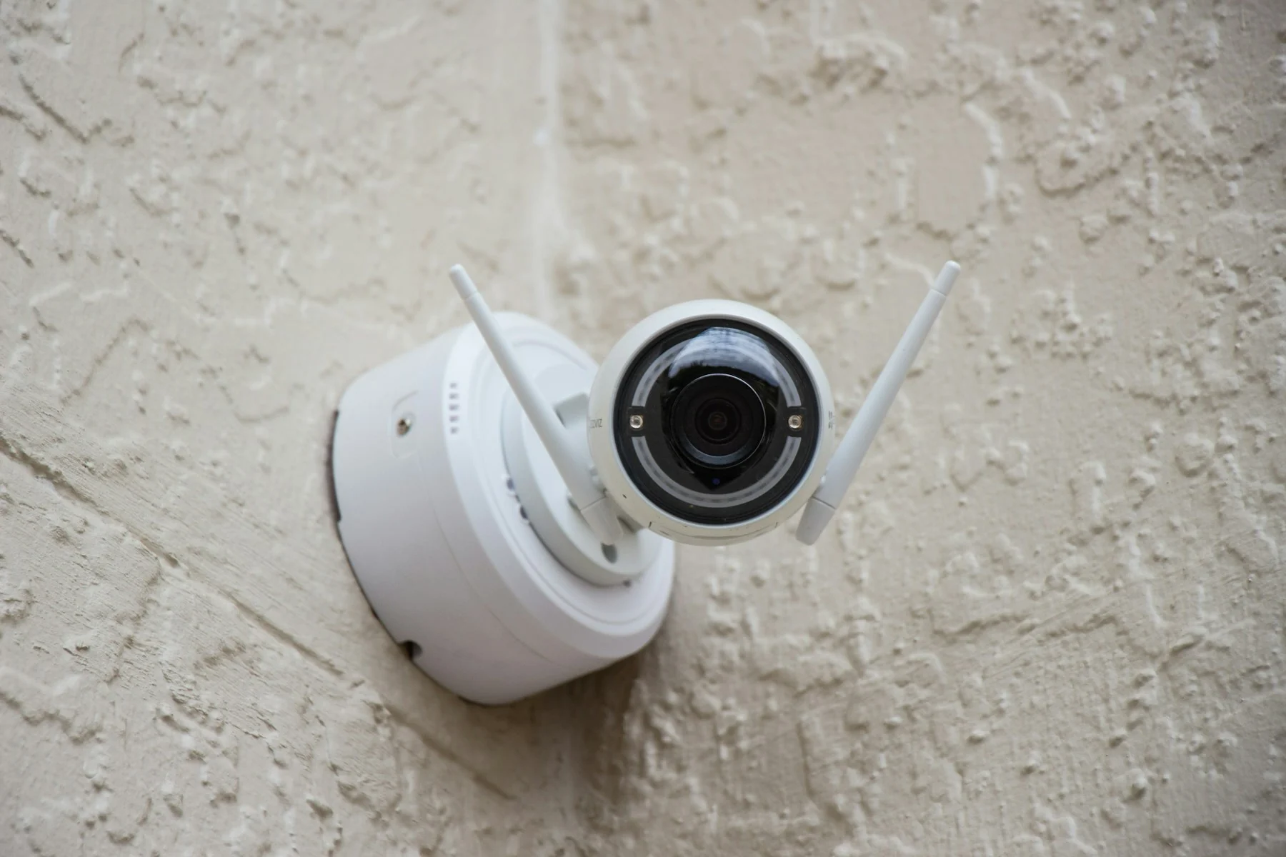 Überwachungskamera an einer verputzten Hauswand