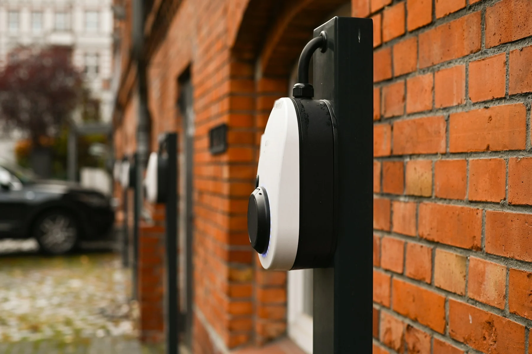 Wallbox an einer Klinkerfassade vor einer Reihenhauszeile