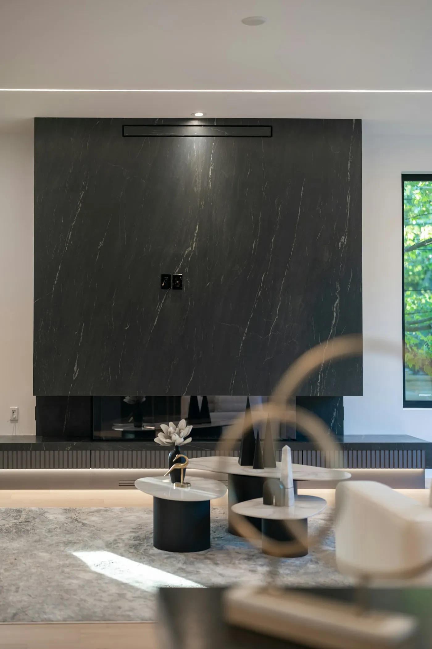 Wohnraum mit Kaminwand aus dunkler Natursteinplatte