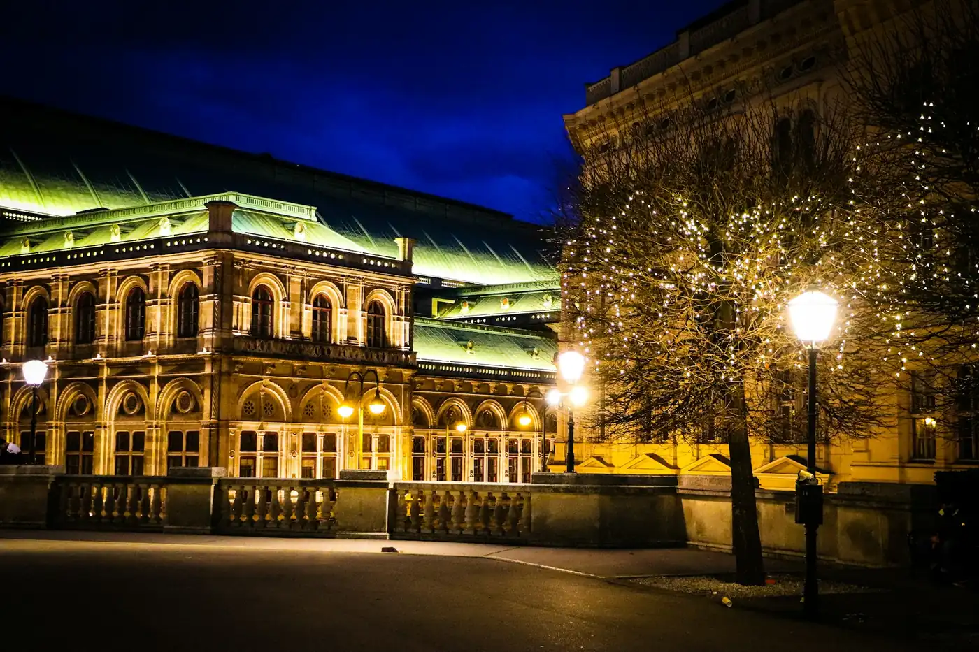 Die Wiener Staatsoper am Abend, beleuchtet vor tiefblauem Himmel